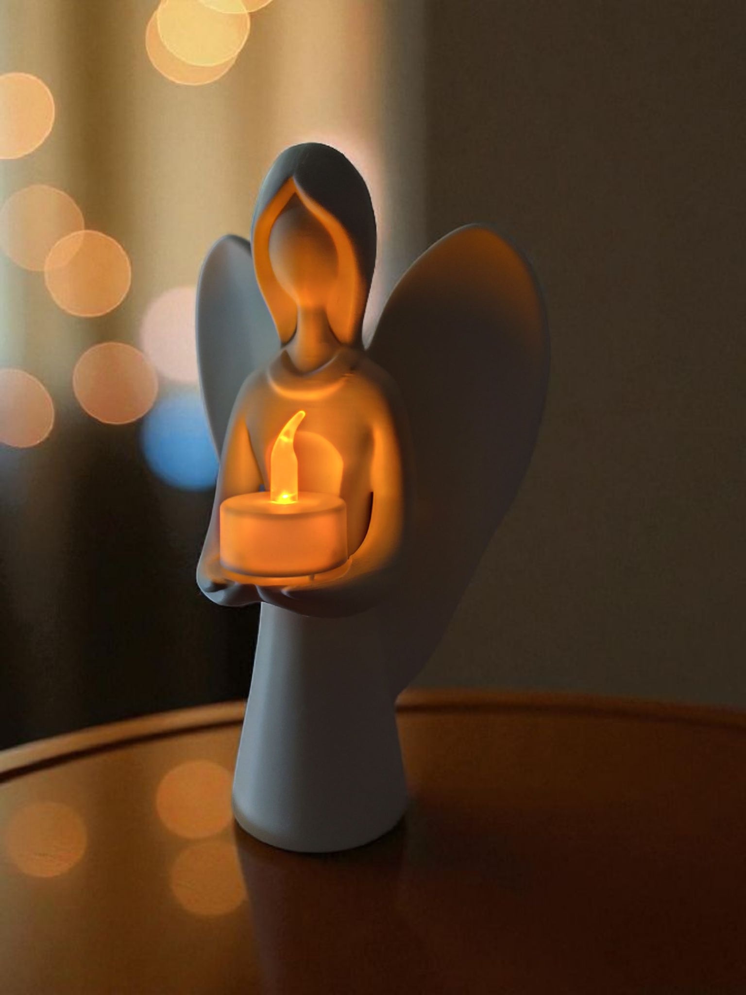 Hvid engel figur med LED fyrfadslys på bord